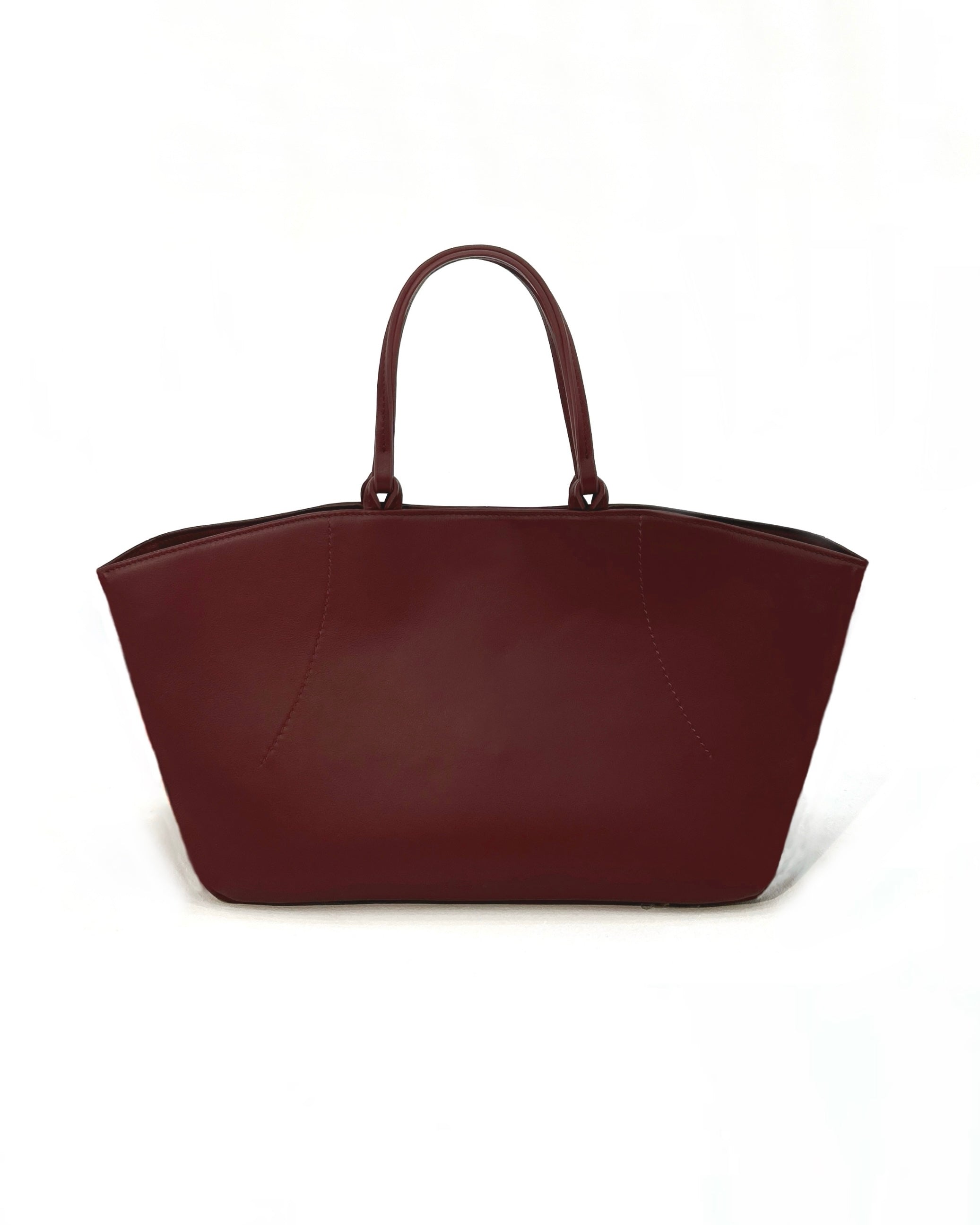 The Colette Tote bag. Made from a gorgeous dark red cowhide leather. Top handle bag with a twist lock closure. Features 3 interior zip pockets. Designed to last 