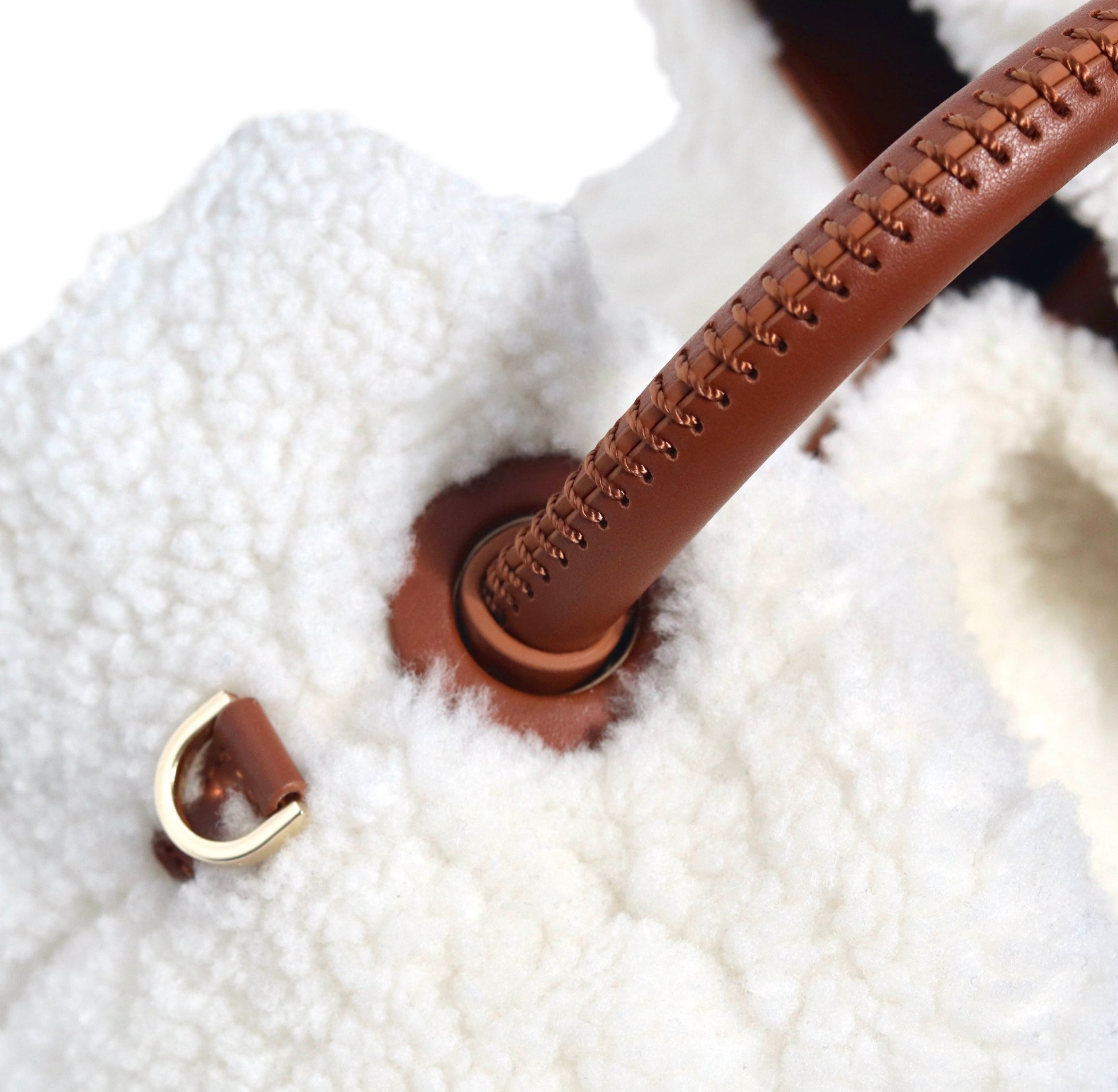 The Celia bag. Made from smooth white shearling wool and brown cowhide leather. Top handle bag. Designed to last 