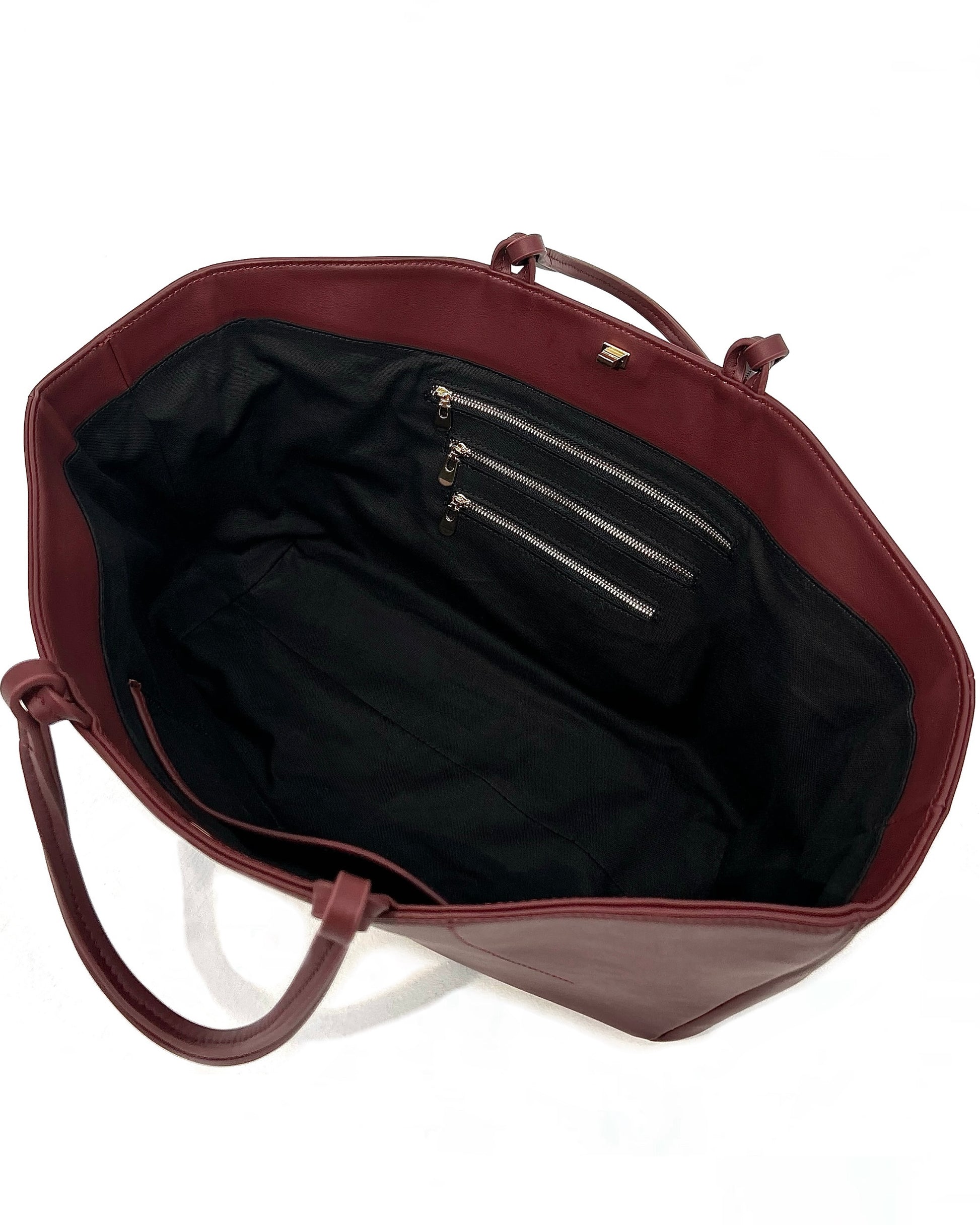 The Colette Tote bag. Made from a gorgeous dark red cowhide leather. Top handle bag with a twist lock closure. Features 3 interior zip pockets. Designed to last 