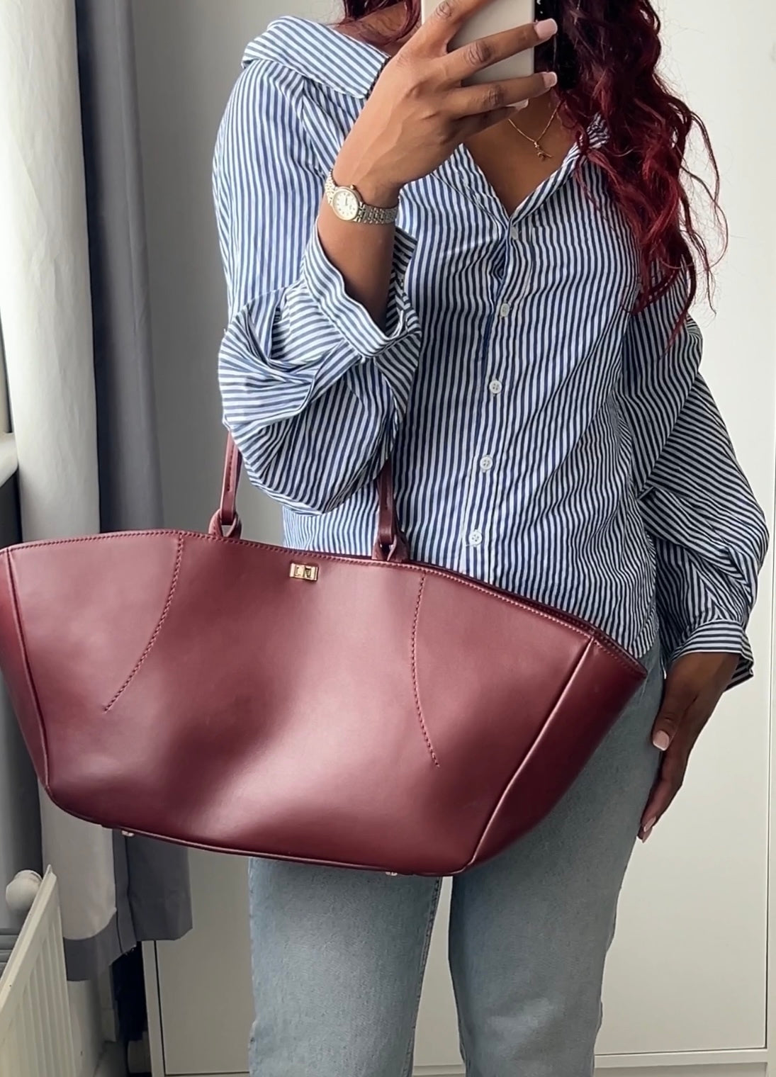 The Colette Tote bag. Made from a gorgeous dark red cowhide leather. Top handle bag with a twist lock closure. Features 3 interior zip pockets. Designed to last 